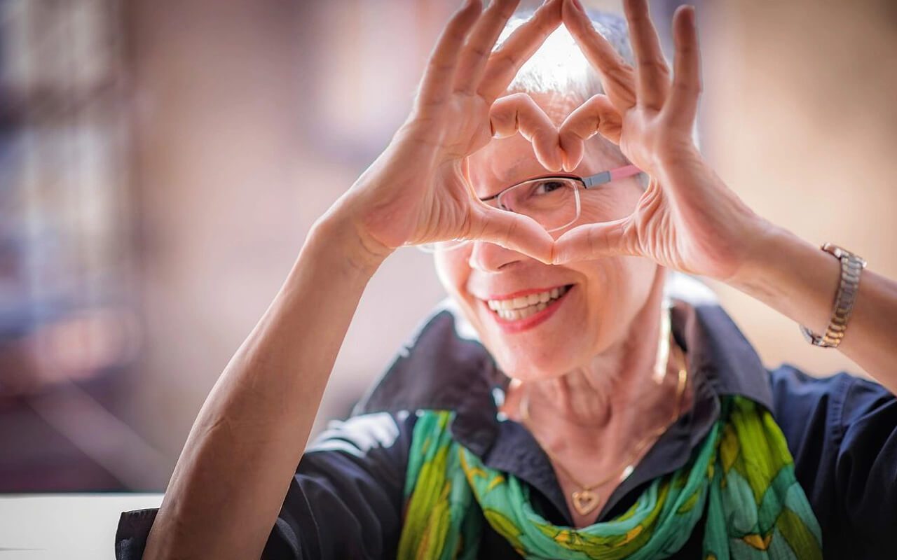 A woman making a heart with her hands.